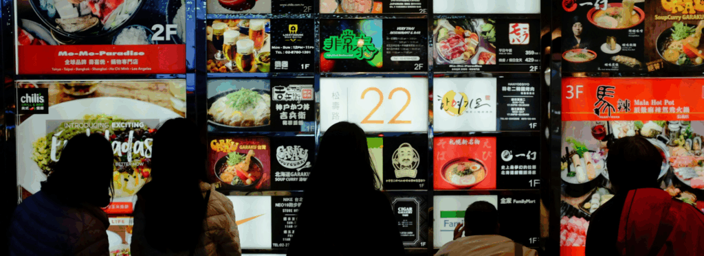 Άτομα που κοιτάζουν έναν μεγάλο κατάλογο φαγητού, απεικονίζοντας την κατάρα των πολλών επιλογών
